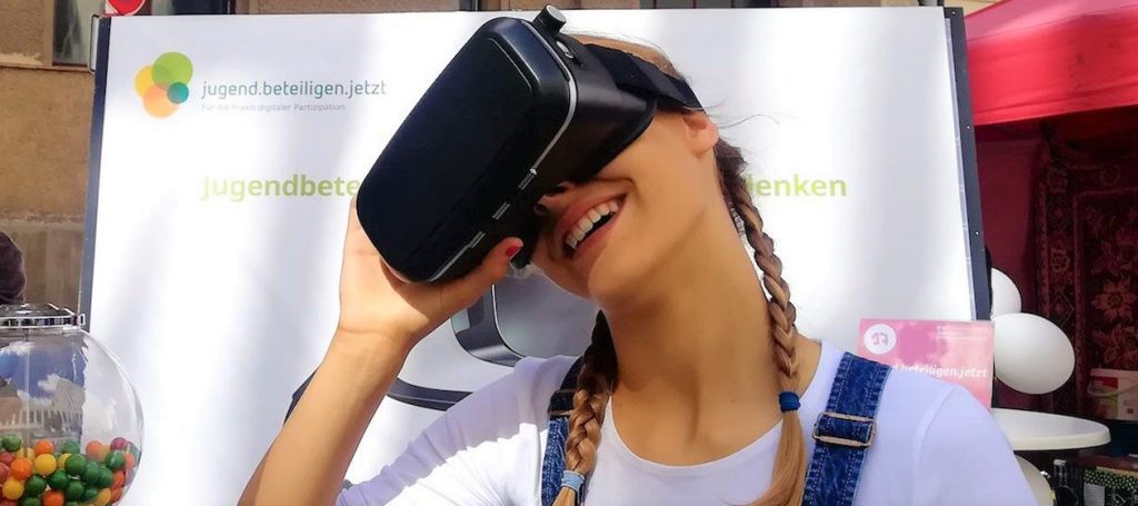 Eine Person trägt eine VR-Brille und lacht.