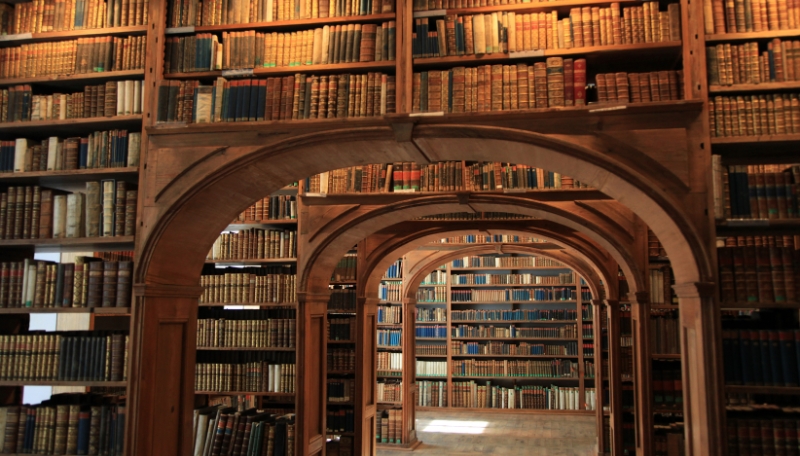 große, alte Bücherregale, die in der Mitte einen Durchgang haben